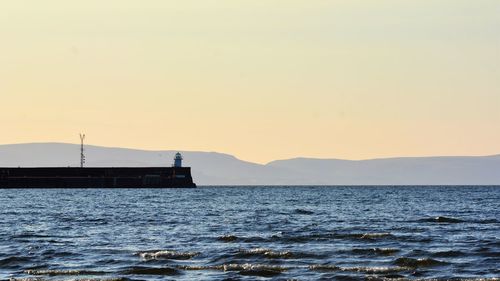 Scenic view of sea against clear sky during sunset