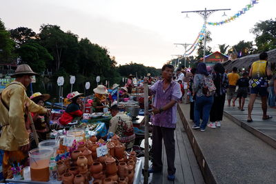 People on street market in city against sky