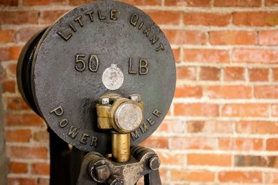 Close-up of telephone on brick wall