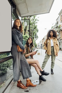 Young women waiting while standing at bus stop