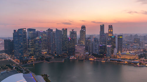 Illuminated buildings in city during sunset