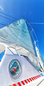 Low angle view of sailboat against blue sky