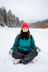 Rear view of woman skiing on snow covered field