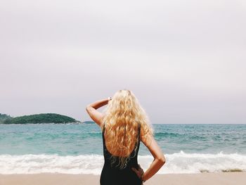 Rear view of woman looking at sea against sky