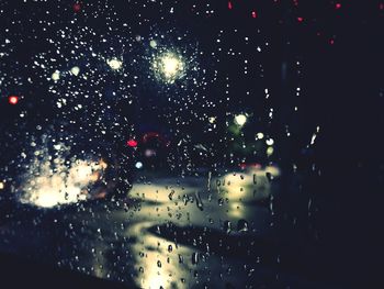 Cars on road seen through wet window at night