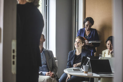 Business colleagues sitting in board room during meeting at office