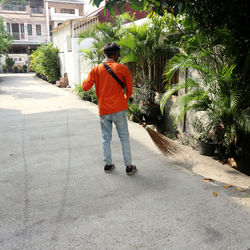 Rear view of man walking on footpath