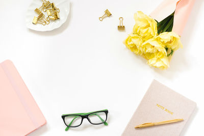 Spring trend minimalist flat lay of the workplace in the office. notepad, pen, gold-colored paper