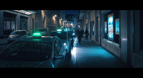 Cars parked on illuminated street at night