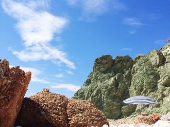 Low angle view of rocks against blue sky