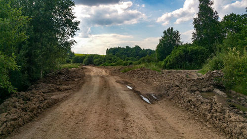 Road amidst field against sky