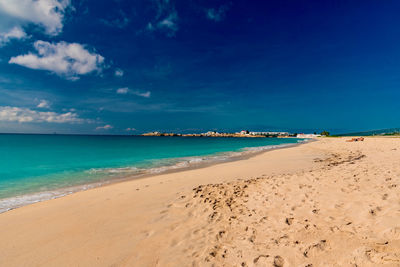 Scenic view of beach against blue sky