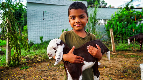 Indian little boy holding the small goat. friendship of child and yeanling, image toned.