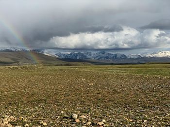 Scenic view of field against sky with rainbow