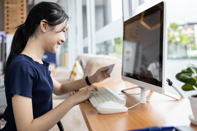 Side view of woman using mobile phone