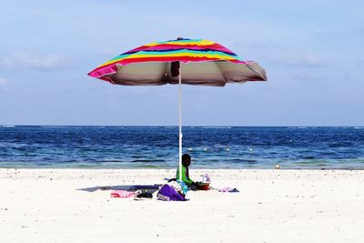 Umbrellas on beach against sky