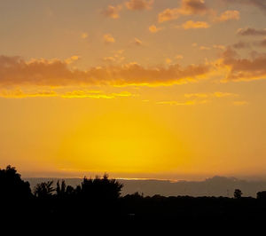 Scenic view of silhouette landscape against orange sky