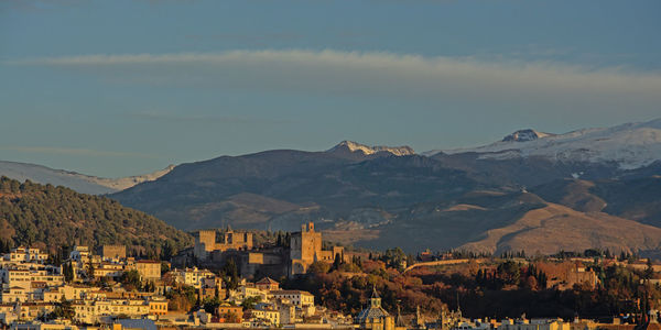 Panoramic view of townscape and mountains against sky