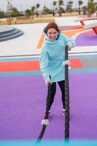 Portrait of smiling young woman standing on soccer field