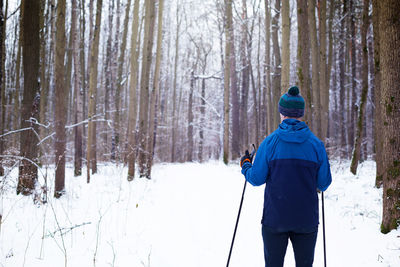 Rear view of man standing on snow covered land