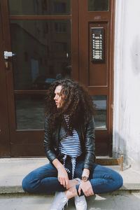 Side view of woman sitting in front of building