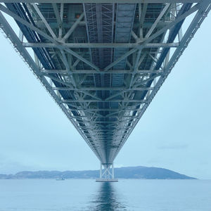 Low angle view of bridge over sea against sky