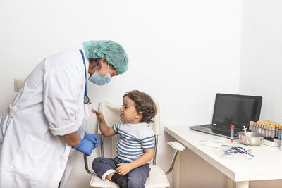 Female doctor examining kid little child boy.