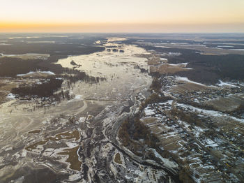 Aerial view of snow covered landscape during sunset