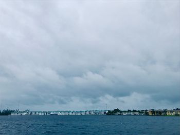 Scenic view of sea by buildings against sky