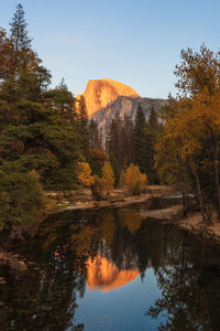 Reflection of trees in lake against mountains during autumn