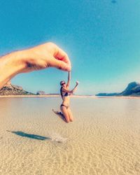 Woman on beach against clear blue sky