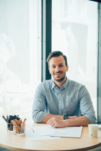 Portrait of young man sitting at table