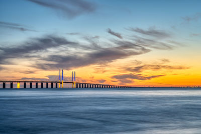 The famous oeresund bridge after sunset with the lights of copenhagen in the distance