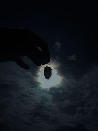 Low angle view of silhouette hand against sky