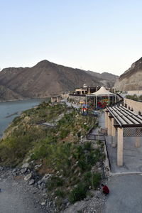 Scenic view of building by mountains against clear sky