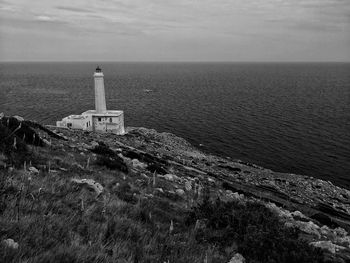 Lighthouse by sea against sky