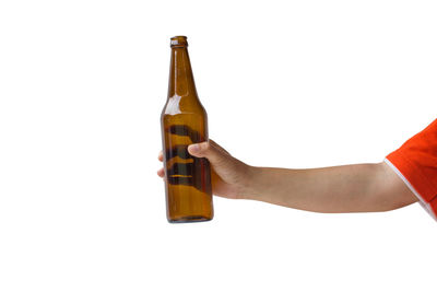 Midsection of man holding glass bottle against white background