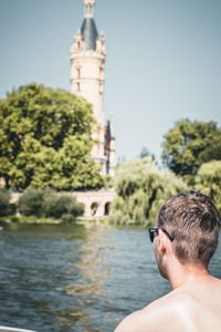 Portrait of man by lake against sky