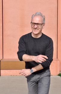 Portrait of smiling man standing against wall