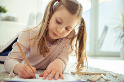 Close-up of girl drawing in book at home