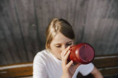 High angle view of girl drinking water at basketball court