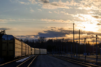 Road by city against sky during sunset