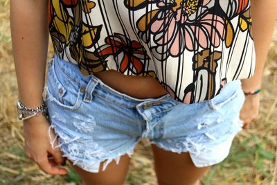 Midsection of young woman standing on field