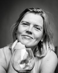 Portrait of smiling woman against black background