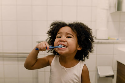 Girl brushing teeth in bathroom