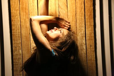 Portrait of young woman resting on wooden floor