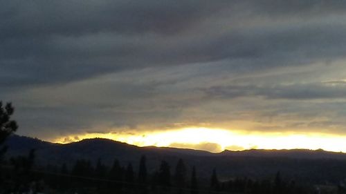 Scenic view of silhouette mountains against dramatic sky