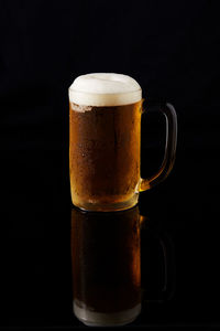 Close-up of beer glass against black background
