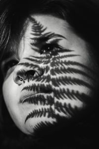 Shadow of fern on woman's face