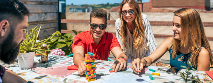 Group of office workers playing with jenga game on terrace